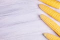 Fresh yellow corn on the cob kernels on a white wooden background. Royalty Free Stock Photo