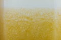 Fresh yellow fruits juice background texture with foam. Orange water bubbles. Macro. Royalty Free Stock Photo