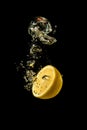 Fresh yellow lemon half in water splash on black background with lots of air bubbles