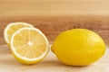 Fresh yellow lemon and half a lemon on a wooden table