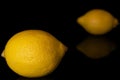 Fresh yellow lemon isolated on black glass Royalty Free Stock Photo