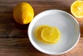 Yellow lemon with lemon slices on a white ceramic plate top view Royalty Free Stock Photo