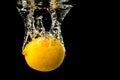 Fresh yellow lemon in water splash on black background with lots of air bubbles Royalty Free Stock Photo