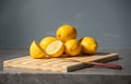 Fresh yellow lemons stacked on stone table top surface of marble kitchen background. Citrus half cutting by knife on wooden board Royalty Free Stock Photo