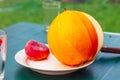 Fresh yellow melon with a cut off piece is lying on a white plate on the table. Fruits and vitamins for Royalty Free Stock Photo