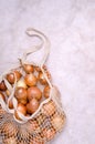 Fresh yellow onions in a knitted bag Royalty Free Stock Photo
