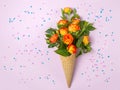 Fresh yellow-orange roses in a waffle cone on a pink background with stars. Flat lay. Original packaging of the bouquet Royalty Free Stock Photo