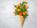 Fresh yellow-orange roses in a waffle cone on a white concrete background. Flat lay. Original packaging of the bouquet Royalty Free Stock Photo