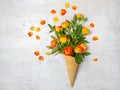 Fresh yellow-orange roses in a waffle cone on a white concrete background. Flat lay. Original packaging of the bouquet. Rose Royalty Free Stock Photo