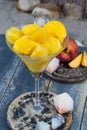 Fresh yellow peach ice-cream scoops in glass cone on the beach, Royalty Free Stock Photo