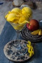 Fresh yellow peach ice-cream scoops in glass cone on the beach, Royalty Free Stock Photo