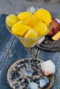 Fresh yellow peach ice-cream scoops in glass cone on the beach, Royalty Free Stock Photo