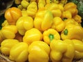 Fresh yellow peppers on a wicker plate in the store Royalty Free Stock Photo