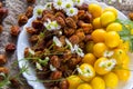 Fresh yellow plum berries and Dried orange plum berrieson a white plate. White daisy flowers and a green wormwood branch. Royalty Free Stock Photo