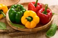 Fresh yellow, red and green bell peppers in a bamboo basket Royalty Free Stock Photo