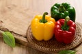 Fresh yellow, red and green bell peppers on wooden background Royalty Free Stock Photo