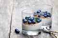 Fresh yogurt in a glass with whole flax and blueberries on wood