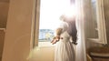Fresh of young woman open a curtains and stretching in bed after waking up, sunlight in morning and open the curtain with lens