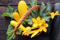 Fresh zucchini in a basket. Zucchini with flowers on the old rustic wooden table Royalty Free Stock Photo