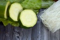 Fresh zucchini, lettuce, noodels on a wooden gray table