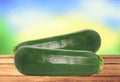 Fresh zucchini on wooden table over nature background Royalty Free Stock Photo