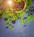 Freshly assorted berries in wooden bowl. Juicy and fresh blueberries6 blackberries and raspberries with green leaves on rustic Royalty Free Stock Photo