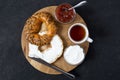 Freshly baked bagel bagel with cream cheese, jam and a cup of tea. Breakfast on the wooden tray