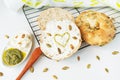 A freshly baked bagel with Philadelphia cheese, sunflower seeds scattered on the table and a heart painted with pesto sauce. Royalty Free Stock Photo