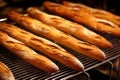 freshly baked baguettes cooling on metal grates