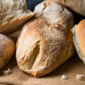 Freshly baked bread on burlap dark wooden background square