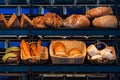 Freshly baked bread on a shelves in bakery, baguette and rolls. Different types of delicious loaves of bread in a german baker