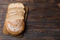 Freshly baked bread slices on cutting board against white wooden background. top view Sliced bread Royalty Free Stock Photo