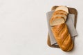 Freshly baked bread slices on cutting board against white wooden background. top view Sliced bread Royalty Free Stock Photo