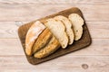 Freshly baked bread slices on cutting board against white wooden background. top view Sliced bread Royalty Free Stock Photo