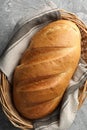 Freshly baked bread in wicker basket on grey table, top view Royalty Free Stock Photo
