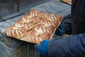 Freshly baked buns on a tray in the hands of a faceless man. Small family bakery. concept of local products. blurred Royalty Free Stock Photo