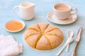 Freshly baked carrot scones with cream, honey and cup of tea with milk on light blue background Royalty Free Stock Photo