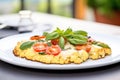 freshly baked cauliflower pizza with basil leaves on a white plate