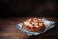 Freshly baked cherry cake with almond slivers on a blue kitchen towel and dark rustic wood, large copy space Royalty Free Stock Photo