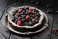 Freshly baked chocolate cake kladdkaka with berries and icing sugar in vintage dish on black background Royalty Free Stock Photo