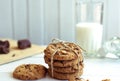 Freshly baked chocolate chip cookies with glass of milk on rustic wooden table. Royalty Free Stock Photo