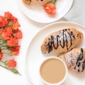 Freshly baked chocolate croissants and cup of coffee on white. Top view. Female spring breakfast concept. Copy space. Royalty Free Stock Photo