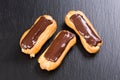 Freshly baked chocolate eclairs on black background. Royalty Free Stock Photo