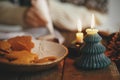 Freshly baked christmas gingerbread cookies in plate and stylish candle on background of woman decorating cookies on rustic table