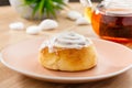 Freshly baked cinnabon roll with sweet glaze on pink plate with Royalty Free Stock Photo