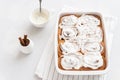 Freshly baked cinnabons or cinnamon rolls with creamcheese frosting on white background. Side view. Bakery menu, recipe, cook book