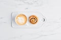 Freshly baked cinnamon roll and coffee with latte art