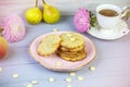 Freshly baked coconut cookies with white chocolate on a beautiful plate, on a gray wooden background, surrounded by a cup of tea, Royalty Free Stock Photo