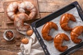 Freshly baked crescent rolls on wooden table, top view