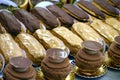 Freshly baked crispy oblong and round pastry coffee and chocolate eclairs with in foreground a chocolate choux